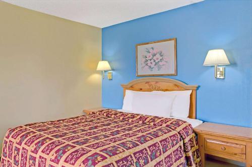 A bed or beds in a room at Days Inn by Wyndham Lehi