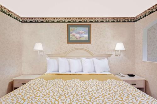 a hotel room with a large bed with white pillows at Your Place Inn in Millington