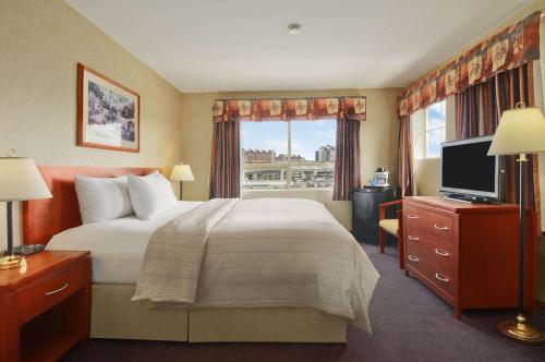 um quarto de hotel com uma cama grande e uma janela em Days Inn by Wyndham Vancouver Airport em Richmond