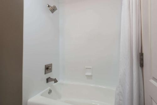 a bathroom with a white tub and a sink at Hotel 1550 - SFO Airport West in San Bruno
