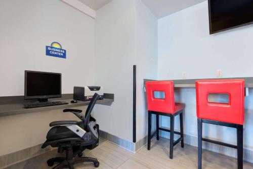 two red chairs sitting next to a desk with a computer at Hotel 1550 - SFO Airport West in San Bruno