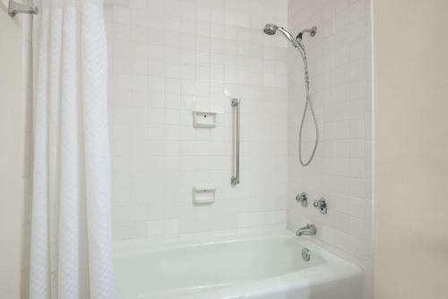 une salle de bain blanche avec une douche et une baignoire dans l'établissement Days Inn by Wyndham Colorado City, à Colorado City