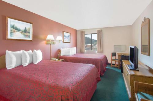 カスターにあるDays Inn by Wyndham Custerのベッド2台、薄型テレビが備わるホテルルームです。
