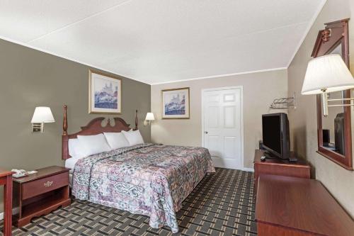 a hotel room with a bed and a tv at Days Inn by Wyndham Lenoir City in Lenoir City