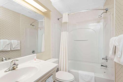 a white bathroom with a sink and a toilet at Days Inn by Wyndham Tannersville in Tannersville