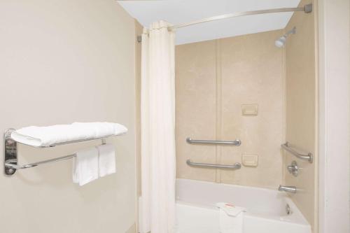 uma casa de banho com um chuveiro, uma banheira e um WC. em Days Inn by Wyndham Nacogdoches/SFA University/Downtown em Nacogdoches