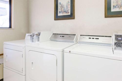 a laundry room with white washers and dryers at Days Inn by Wyndham Maumee/Toledo in Maumee