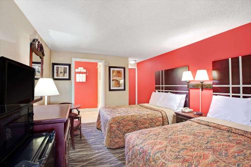 ein Hotelzimmer mit 2 Betten und einem Flachbild-TV in der Unterkunft Days Inn by Wyndham Ridgefield NJ in Ridgefield