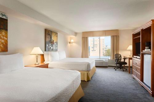 a hotel room with two beds and a window at Days Inn by Wyndham Niagara Falls Centre St By the Falls in Niagara Falls