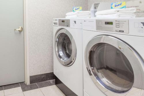 a washing machine in a room with a washer at Days Inn & Suites by Wyndham Huntsville in Huntsville