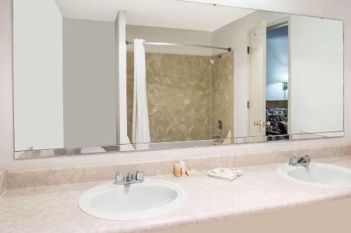 a bathroom with two sinks and a large mirror at Days Inn by Wyndham Corvallis in Corvallis