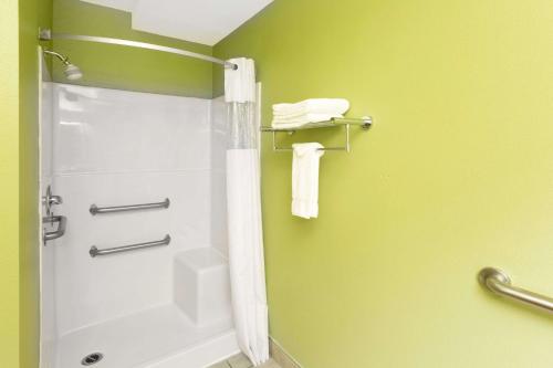 a bathroom with a shower and a toilet and towels at Days Inn by Wyndham Newport OR in Newport