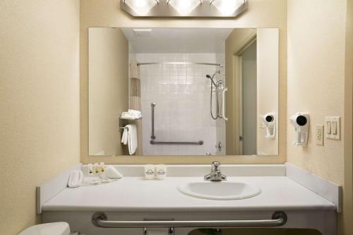 uma casa de banho com um lavatório e um espelho em Days Inn by Wyndham Moose Jaw em Moose Jaw