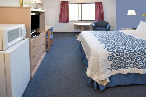 a hotel room with a bed and a television at Days Inn by Wyndham Corvallis in Corvallis