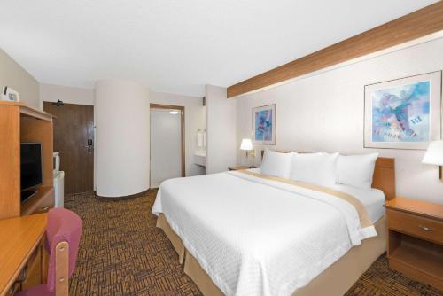 a hotel room with a large bed and a television at Days Inn by Wyndham Liberal KS in Liberal