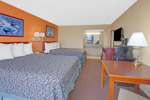 a hotel room with two beds and a desk at Days Inn by Wyndham Okemah in Okemah