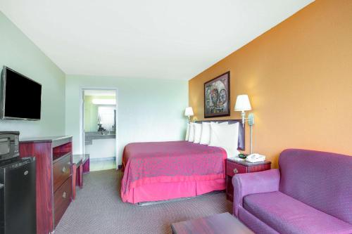 a hotel room with a bed and a couch at Days Inn by Wyndham Okemah in Okemah