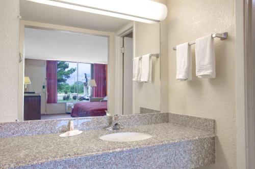 a bathroom with a sink and a large mirror at Days Inn by Wyndham Okemah in Okemah