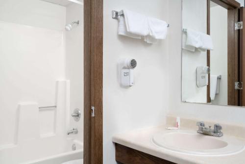 a bathroom with a sink and a mirror at Days Inn by Wyndham St Cloud in Saint Cloud