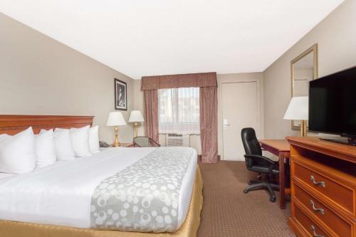 a hotel room with a bed and a desk and a television at Days Inn by Wyndham St Augustine/Historic Downtown in Saint Augustine