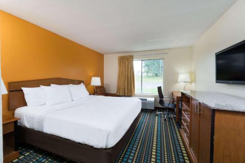 a hotel room with a bed and a flat screen tv at Days Inn by Wyndham Florence Cincinnati Area in Florence