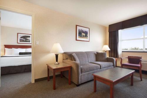 a hotel room with a couch and a bed at Days Inn & Suites by Wyndham Langley in Langley
