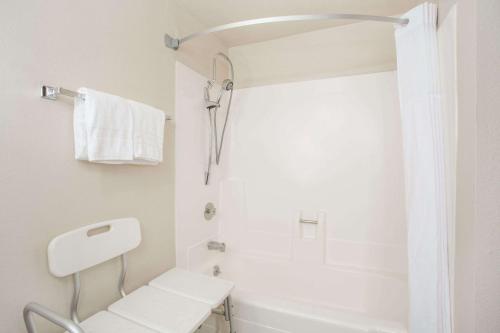 a white bathroom with a toilet and a shower at Days Hotel by Wyndham Peoria Glendale Area in Peoria