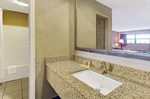 een badkamer met een wastafel en een spiegel bij Days Inn by Wyndham Cherokee Near Casino in Cherokee