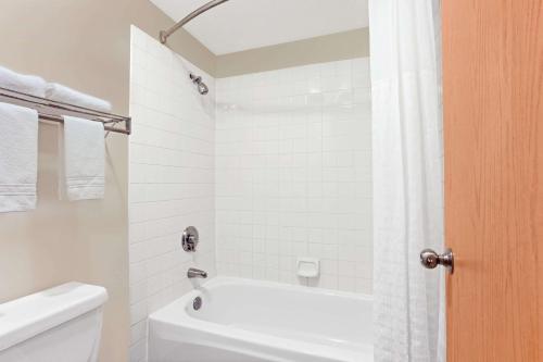 a bathroom with a white tub and a toilet and a shower at Days Inn by Wyndham Federal Way in Federal Way