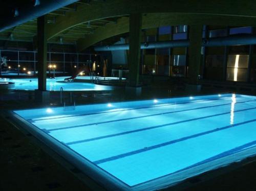 a swimming pool with blue lights in a building at Apartmán Adam in Lipno nad Vltavou