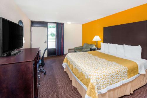 a hotel room with a bed and a flat screen tv at Days Inn by Wyndham Calvert City - Paducah East in Calvert City