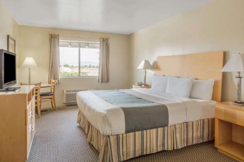 a hotel room with a large bed and a television at Days Inn by Wyndham Chino Valley in Chino Valley