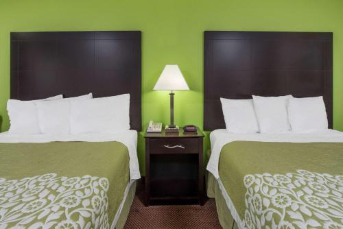 2 camas en una habitación de hotel con paredes verdes en Days Inn by Wyndham Calvert City - Paducah East, en Calvert City