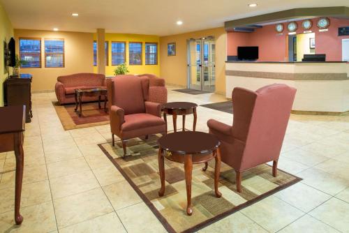 a waiting room with chairs and a table and a counter at Days Inn & Suites by Wyndham Spokane Airport Airway Heights in Airway Heights