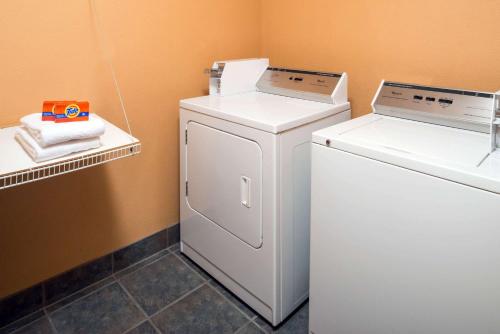 a laundry room with a washer and a dryer at Days Inn & Suites by Wyndham Spokane Airport Airway Heights in Airway Heights