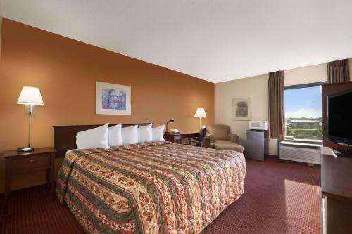 Un pat sau paturi într-o cameră la Days Inn & Suites by Wyndham Cedar Rapids