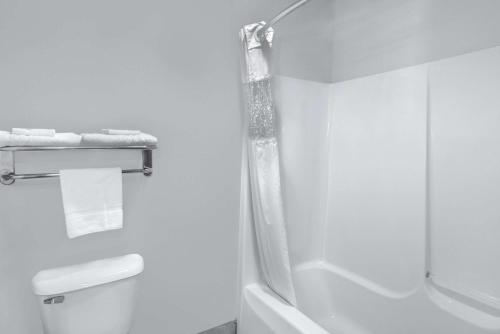 een witte badkamer met een douche en een toilet bij Days Inn by Wyndham Carroll in Carroll