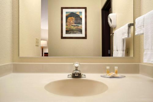 a bathroom sink with a faucet in front of a mirror at Colony Inn in Kent