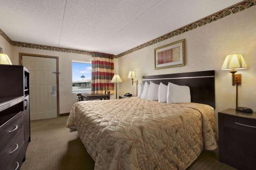 a hotel room with a bed and a television at Days Inn by Wyndham Grantville in Grantville