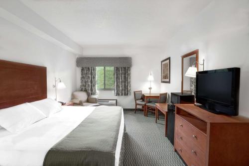 een hotelkamer met een bed en een flatscreen-tv bij Days Inn by Wyndham Carroll in Carroll