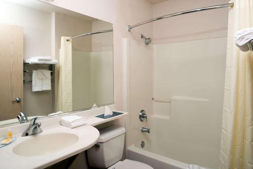 a bathroom with a sink and a toilet and a shower at Days Inn & Suites by Wyndham Spokane Airport Airway Heights in Airway Heights