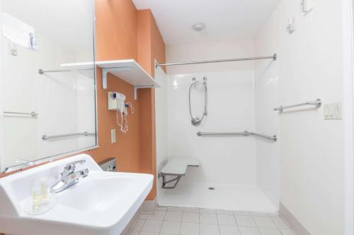 uma casa de banho com um lavatório e um chuveiro em Days Inn & Suites by Wyndham Winnie em Winnie