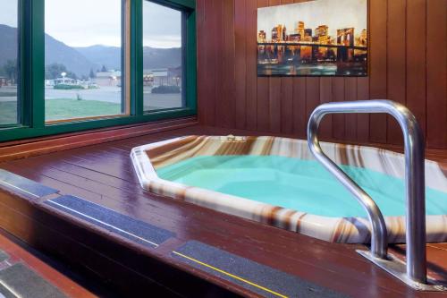 a jacuzzi tub in a room with a window at Days Inn by Wyndham Sandpoint in Ponderay