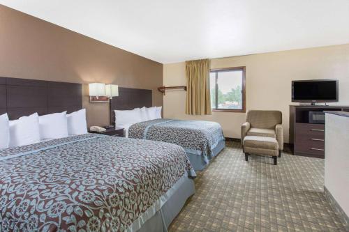 a hotel room with two beds and a television at Days Inn & Suites by Wyndham Waterloo in Waterloo