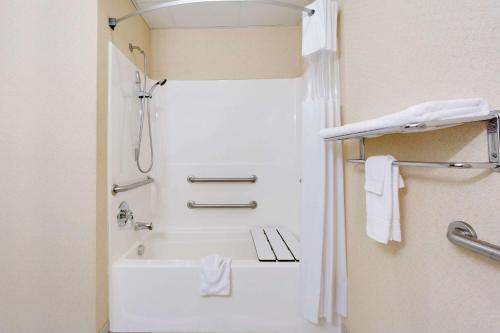 łazienka z prysznicem i białą wanną w obiekcie Magnuson Hotel West Liberty w mieście West Liberty