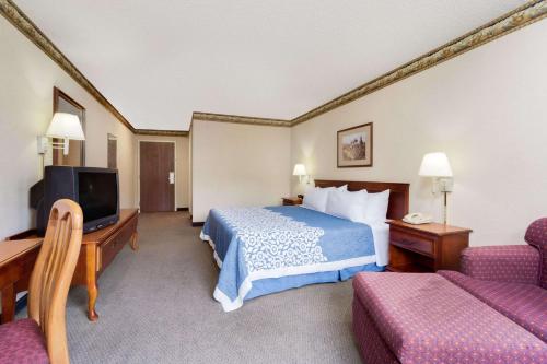 a hotel room with a bed and a tv at Magnuson Hotel West Liberty in West Liberty