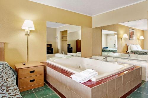 uma grande casa de banho com banheira e 2 lavatórios em Days Inn by Wyndham Knoxville West em Knoxville