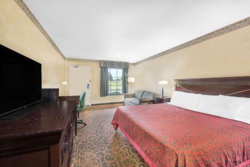 a hotel room with a bed and a flat screen tv at Days Inn & Suites by Wyndham York in York