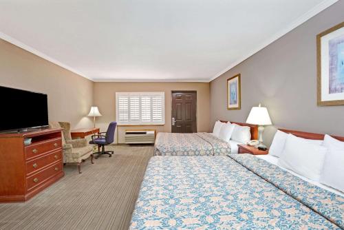 um quarto de hotel com duas camas e uma televisão de ecrã plano em Days Inn by Wyndham West Covina em West Covina