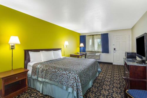 a hotel room with a bed and a flat screen tv at Days Inn by Wyndham Delta in Delta